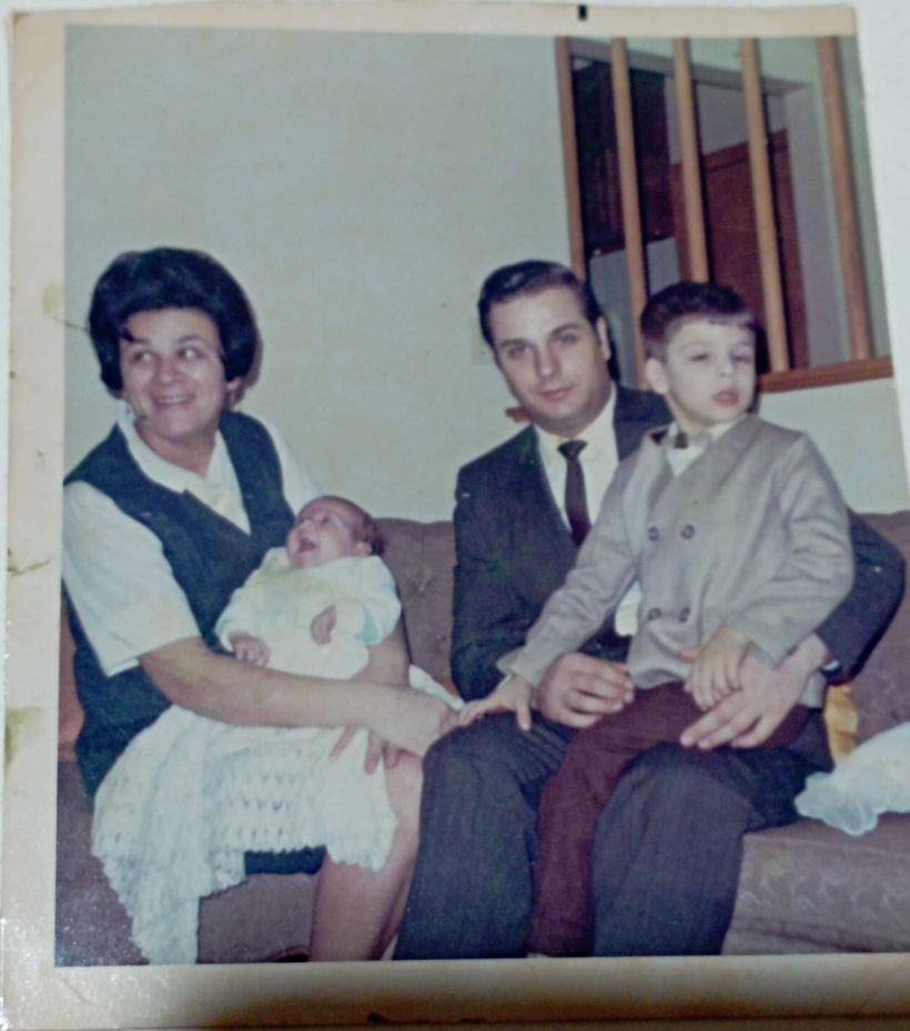 Our parents on the living-room sofa, holding my brother and me as young boys