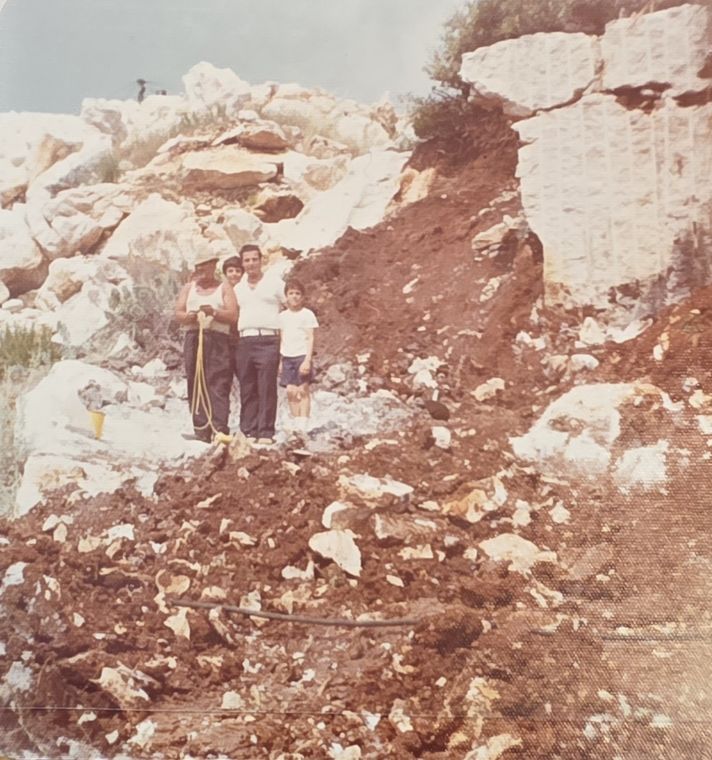 My brother, me, my dad and a quarry worker standing on the white marble rock face