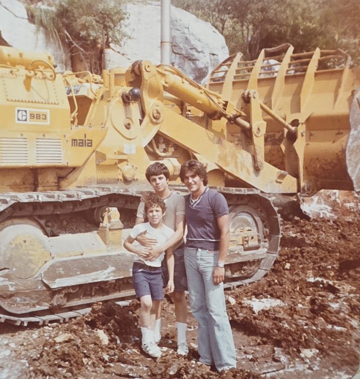 My cousin, my brother and me standing in front of a large yellow loader